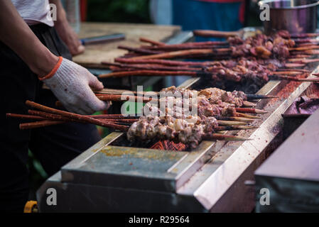 Xi'an, Shaaxi Province, Chine - 19 août 14, 2018 l'homme : la cuisson des viandes en brochettes dans une banlieue musulmane street Banque D'Images