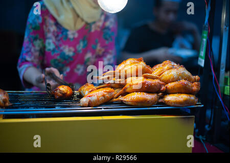 Xi'an, Shaaxi Province, Chine - Aug 14, 2018 : femme de la cuisson du poulet dans un quartier musulman de la rue du marché de nuit Banque D'Images