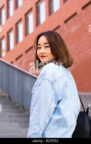 Girl student standing avec sac à dos ou sac d'école sourire heureux. Portrait de jeune femme d'origine asiatique à l'université Banque D'Images