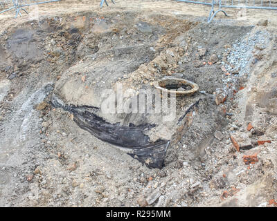 Ancien couvert d'égout dans le sol sur le côté du bâtiment. Couvercle d'égout sur la route dans la ville. Banque D'Images