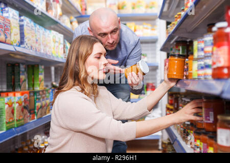 Couple positif de la famille dans le shop holding Jar conservé dans la section d'épicerie Banque D'Images
