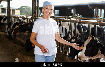 Senior female farmer posing in étable à dairy farm Banque D'Images