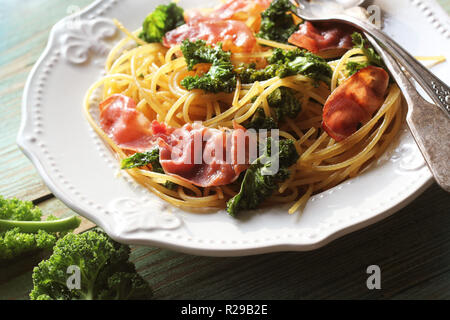 Délicieux avec des pâtes linguine épicées poêlée de chou kale, bacon, l'ail et le parmesan sur une plaque blanche . Vue d'en haut Banque D'Images