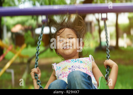 Asian girl swinging et souriant. Filipina kid Banque D'Images