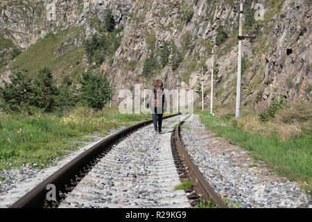 Le voyageur solitaire promenades le long du terrain montagneux le long du chemin de fer. Banque D'Images