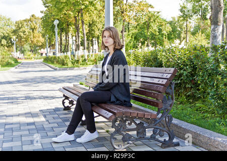 Belle jeune fille de quatorze ans sont assis sur le banc Banque D'Images