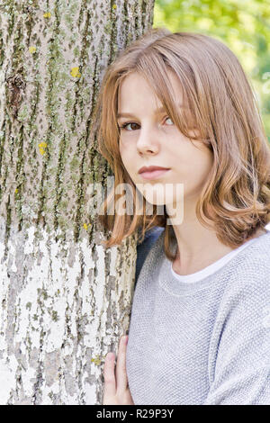 Belle fille de 14 ans s'appuyer contre l'arbre Banque D'Images