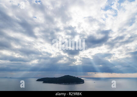 Du soleil qui sort de l'île de Lokrum sur cloudscape en face de Dubrovnik, Croatie Banque D'Images