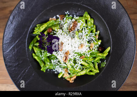 Des pâtes avec du fromage de chèvre et pesto d'épinards sur l'assiette, à la table Banque D'Images