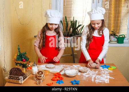 Deux mignonnes petites filles préparer des biscuits de Noël dans la cuisine à la maison Banque D'Images