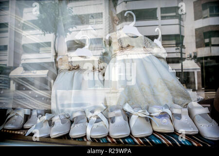 Des robes et des chaussures pour faire la première communion reflétée à l'exposition, conceptual image Banque D'Images