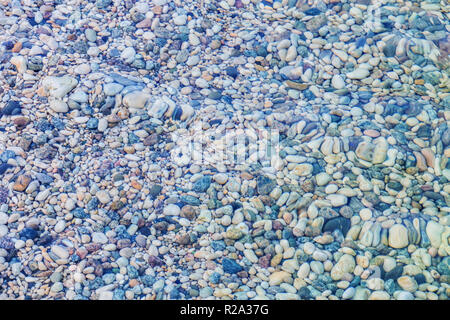 Cailloux multicolores sous l'eau sur le fond de plage Banque D'Images