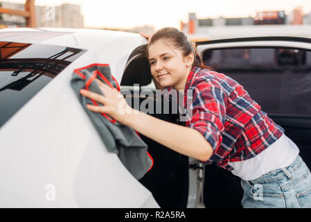 Après lavage automobile lingettes femme sur le libre-service de lavage de voiture. Dame véhicule nettoyage Banque D'Images