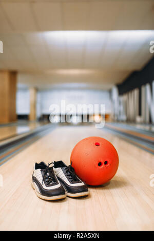 Boule de bowling et chaussures maison sur lane en club, les broches du contexte, personne. Bowl concept, tenpin Banque D'Images