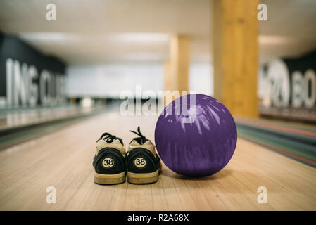 Boule de bowling et chaussures maison sur lane en club, vue rapprochée, personne. Bowl, concept passe-temps actif Banque D'Images