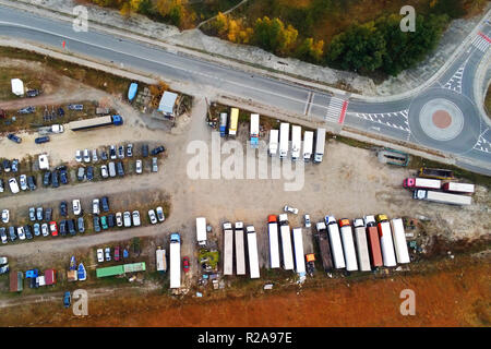 Vue aérienne de naturel non revêtues parking gratuit avec beaucoup de camions, remorques et voitures. Lieu de repos près de road et circle junction Banque D'Images