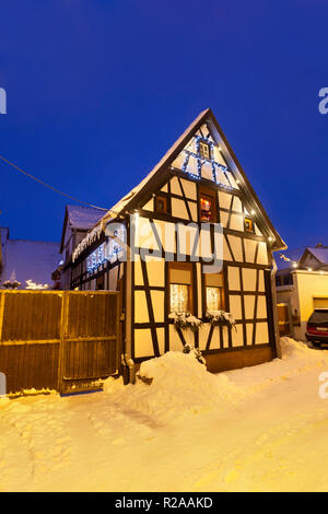 Une allée de maisons à colombages et les lumières de Noël au cours de la nuit de neige dans Lachen, Neustadt an der Weinstrasse, Allemagne. Banque D'Images