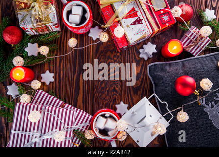 Noël arrière-plan y compris des boîtes-cadeaux, chocolat chaud, branches de sapin et d'autres décorations de table en bois Banque D'Images
