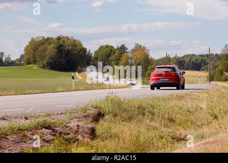 Jarna, Suède - Juillet 10, 2018 : voiture rouge sur la route de campagne dans la province suédoise de Sodermanland. Banque D'Images