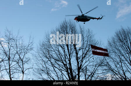 Riga, Lettonie. 18 Nov, 2018. Un hélicoptère militaire avec un drapeau national letton survole le défilé militaire pour le 100e anniversaire de l'état de Lettonie. La Lettonie a célébré son 100e anniversaire le dimanche. L'Etat balte avait proclamé son indépendance il y a exactement un siècle - le 18 novembre 1918 - dans la tourmente après la Première Guerre mondiale. Crédit : Alexander Welscher/dpa/Alamy Live News Banque D'Images