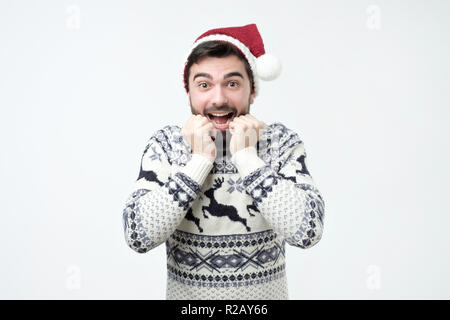 Heureux l'homme hispanique au Père Noël pac est excité et heureux. Banque D'Images