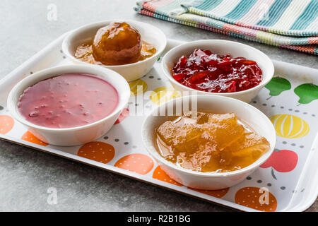 Un assortiment de variété de confitures et marmelades ; Rose, poivron rouge, mandarine et Citron pelez dans un petit bol. L'alimentation biologique. Banque D'Images