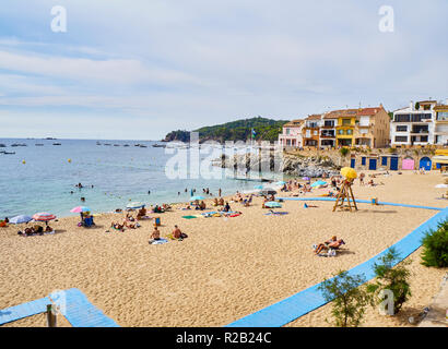 Les touristes bénéficiant d'un bain de soleil à Platja del Canadell, la grande plage de Calella de Palafrugell, Girona, Costa Brava, Catalogne, Espagne. Banque D'Images