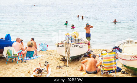 Les touristes bénéficiant d'un bain de soleil à Platja de les barques, une plage de Calella de Palafrugell, Girona, Costa Brava, Catalogne, Espagne. Banque D'Images