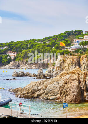 Les touristes visitant Punta dels Burricaires point sous le drapeau officiel de la Catalogne, appelé Senyera. Calella de Palafrugell, Girona, Espagne. Banque D'Images