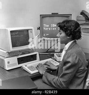 Une femme afro-américaine travaille sur un ordinateur IBM, ca. 1982. Banque D'Images