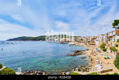 Les touristes bénéficiant d'un bain de soleil à Platja del Canadell, la grande plage de Calella de Palafrugell, Girona, Costa Brava, Catalogne, Espagne. Banque D'Images