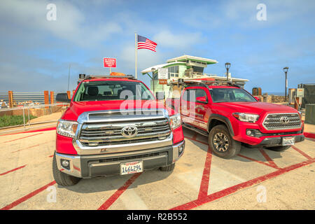 La Jolla, California, United States - 3 août 2018 : Incendie-sauvetage sauveteur américain avec le drapeau américain. Deux véhicules 4x4 Toyota pickup patroling plage de San Diego. Incendie en Californie dans l'océan Pacifique. Banque D'Images