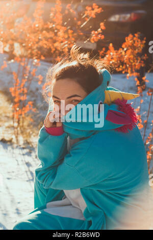 Cute woman dans kigurumi costume unicorn sur rue Banque D'Images