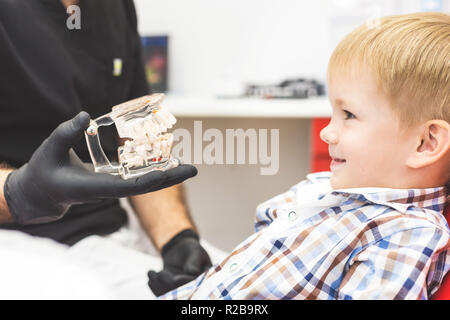 Clinique dentaire. La réception, l'examen du patient. Soins des dents. Male dentist in dental office talking with patient Banque D'Images