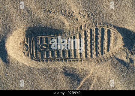 Chaussures de marque Geox empreinte sur le sable d'une plage Banque D'Images