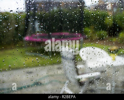 Saison d'automne en regardant par la fenêtre un jour de pluie jardin contexte flou et gouttes de pluie sur la vitre Banque D'Images