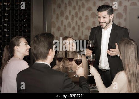 Heureux homme barbu prononcer des toasts sur réunion amicale en agréable restaurant Banque D'Images