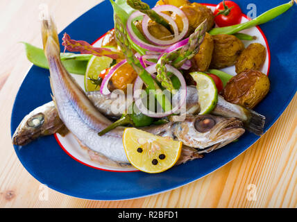 Délicieux ragoût au vin blanc bleu Merlan poisson servi avec pommes de terre rôties et de gousses de pois Banque D'Images