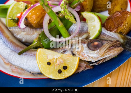 Mijotée dans du vin blanc avec du poisson Merlan bleu garnir des pommes de terre au four et petits pois frais Banque D'Images