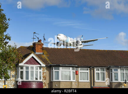 Londres, ANGLETERRE - NOVEMBRE 2018 : Boeing 777 d'Egyptair jet volant bas au-dessus des toits d'atterrir à l'aéroport Heathrow de Londres. Banque D'Images