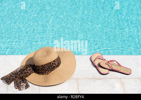 Mesdames chapeau et flip flops =à côté de la piscine Banque D'Images