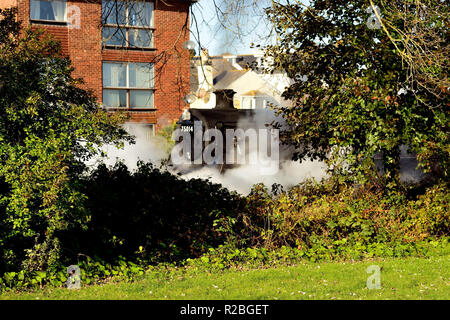 Train à vapeur dans un quartier résidentiel de Paignton au passage à niveau du chemin des sables bitumineux. Banque D'Images