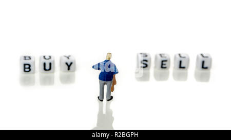 Libre de miniatures de businessman standing in front of white dices avec vendre et acheter des mots écrits sur eux sur fond blanc Banque D'Images