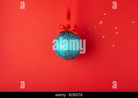 Emerald Boule de Noël avec des ornements d'or suspendu à un ruban rouge. Carte de vacances de style minimal. Banque D'Images