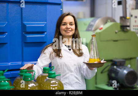 Hot girl grandes bouteilles de remplissage avec de l'huile d'olive en atelier industriel Banque D'Images