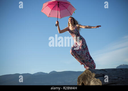 Belle fille montagne prêt à sauter avec parapluie Banque D'Images