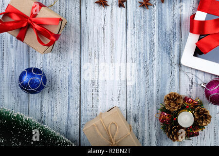 Présente enveloppés de ruban rouge et attributs du nouvel an des boules de Noël, des jouets, des porte-bougie vintage sur fond de bois avec du texte dans l'espace e Banque D'Images