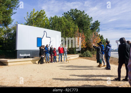 Décembre 27, 2017 Menlo Park / CA / USA - un groupe d'amis posant devant le Facebook Like Button garde située à l'entrée de la société. Banque D'Images