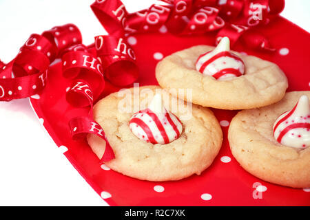 De gros plan sur le sucre blanc à pois rouge et blanc à rayures plaque candy et ruban Noël Curly Banque D'Images