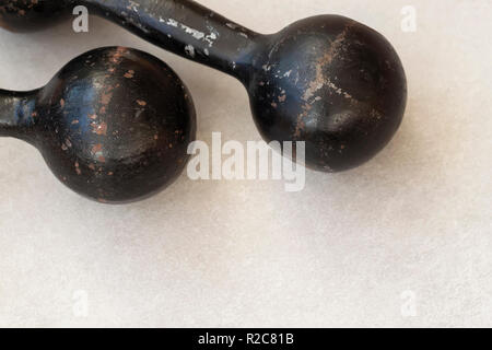 Haltères anciennes en noir sur fond clair, avec un fond de sport copy space Banque D'Images